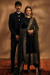 Man and woman in formal attire standing against a warm-toned background