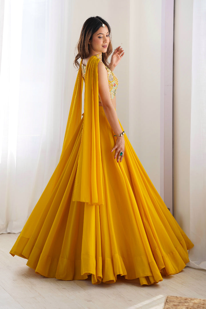 Woman wearing a yellow dress with a cape in a bright room.
