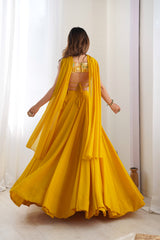 Woman wearing a yellow saree with a white curtain background