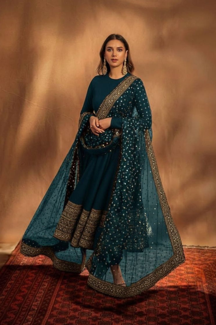 Woman in a traditional blue outfit with gold details against a warm-toned background