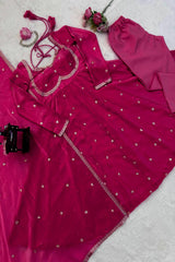 Pink traditional outfit with silver embroidery on a light gray background