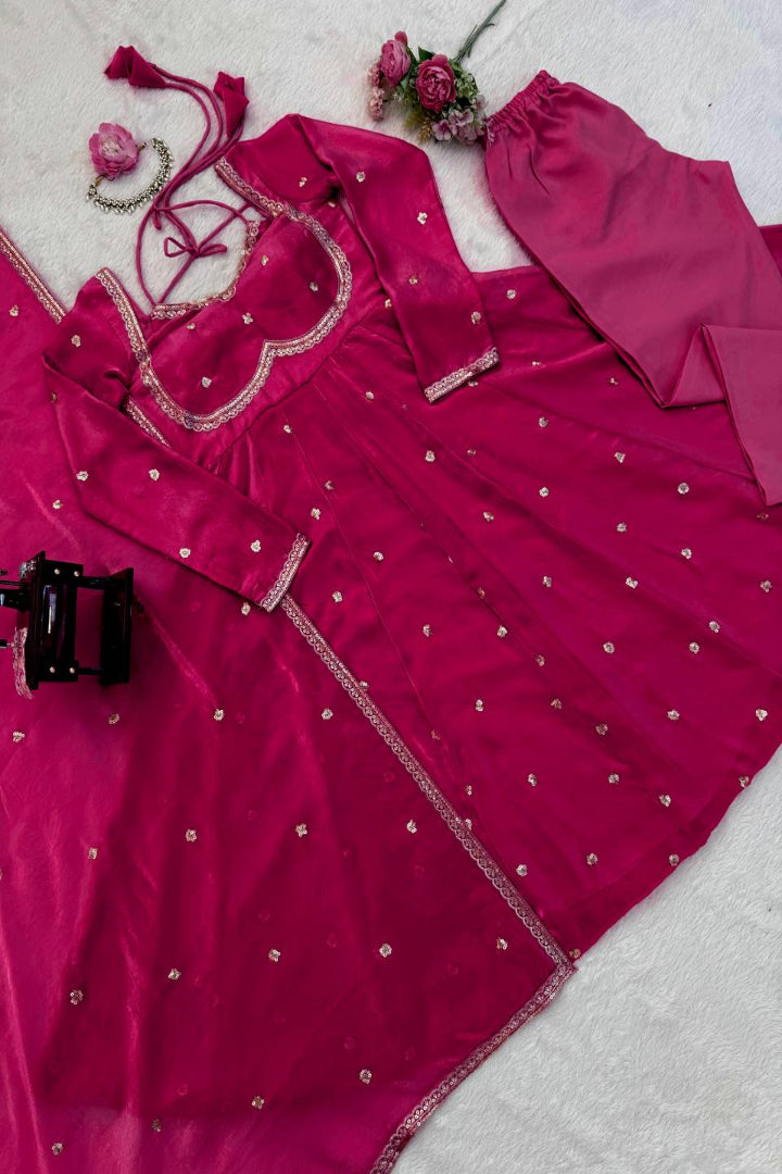 Pink traditional outfit with silver embroidery on a light gray background