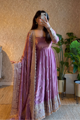 Woman in a PINK traditional outfit taking a mirror selfie in a room with plants.