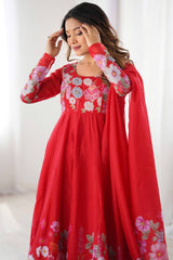 Woman wearing a red traditional outfit with floral embroidery in a bright setting