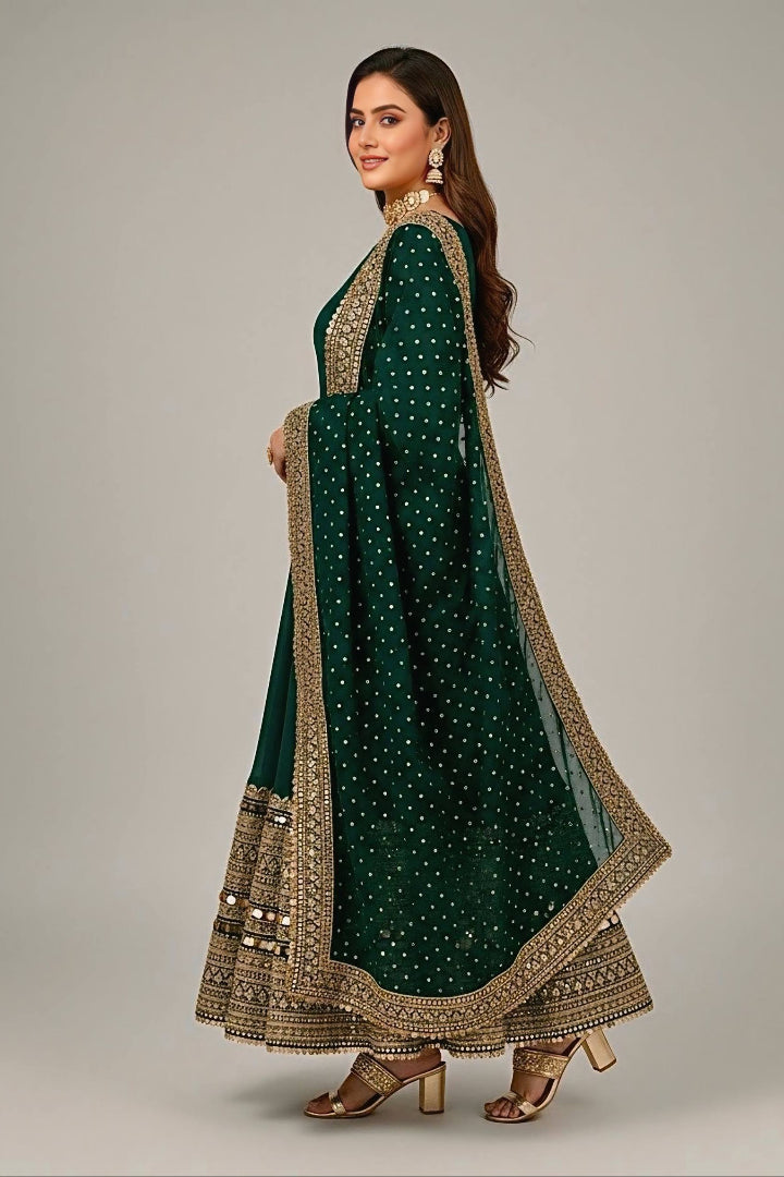 Woman wearing a green traditional outfit with gold embroidery on a gray background