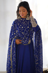 Woman wearing a blue embroidered traditional outfit with a white background