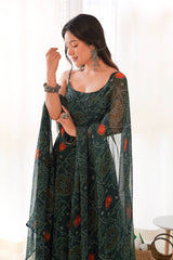 Woman wearing a dark green patterned dress with sheer sleeves indoors.