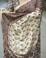 Traditional saree with intricate patterns in beige, red, and blue.