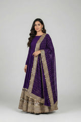 Woman wearing a purple traditional outfit with gold embroidery on a white background