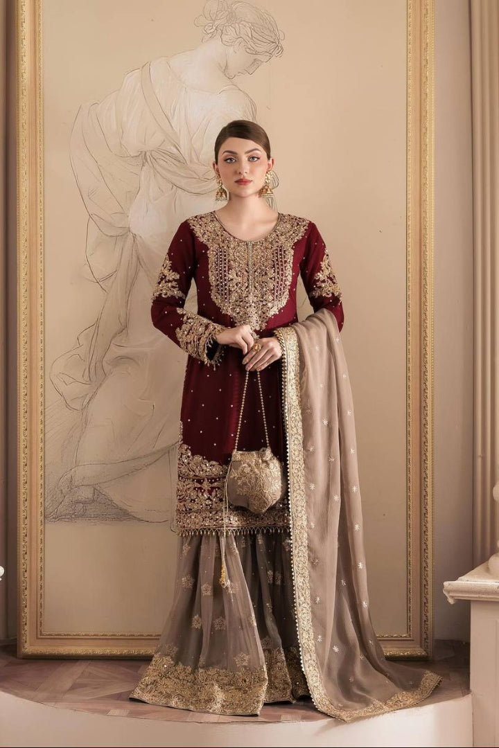 Woman in an ornate traditional outfit standing in a decorated room with classical sculpture.