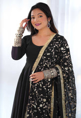 Woman wearing a black and gold traditional outfit with a white background