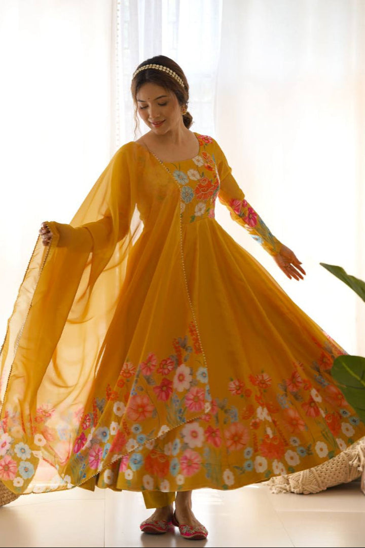 Woman wearing a yellow floral dress in a bright room with white curtains.