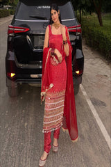 Woman in a red traditional outfit standing in front of a black SUV with 'Jai Baba' written on it.