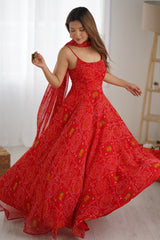 Woman wearing a red patterned dress in a bright room