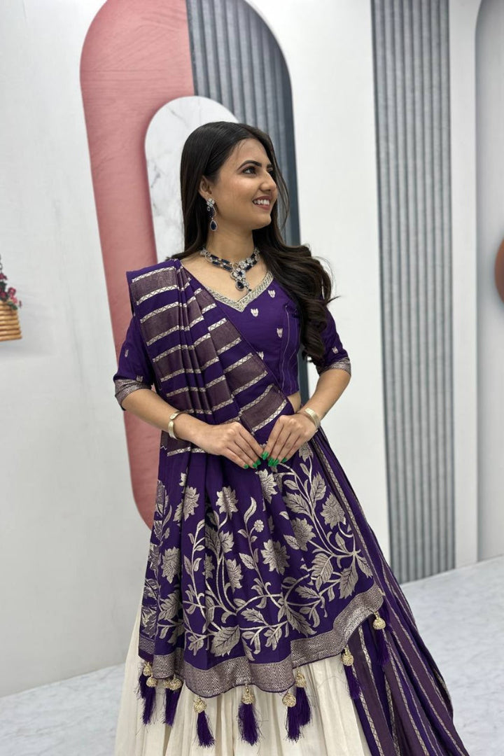 Woman wearing a purple and white traditional outfit with intricate designs.