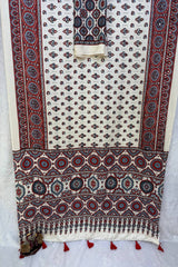 Decorative fabric with intricate patterns and tassels on a white background