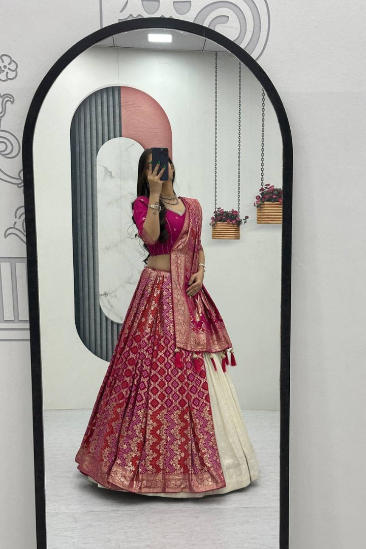 Person wearing a traditional pink and red lehenga in front of a mirror.
