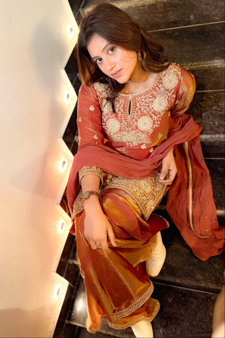 Woman in traditional outfit sitting on a staircase