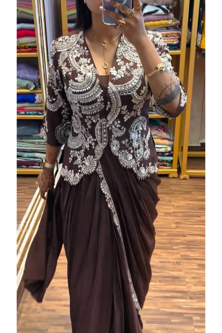 Person wearing a brown saree with white lace details in a store setting.