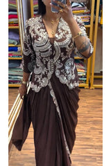 Person wearing a brown saree with white lace details in a store setting.