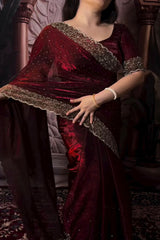 Person wearing a burgundy traditional outfit with intricate detailing.