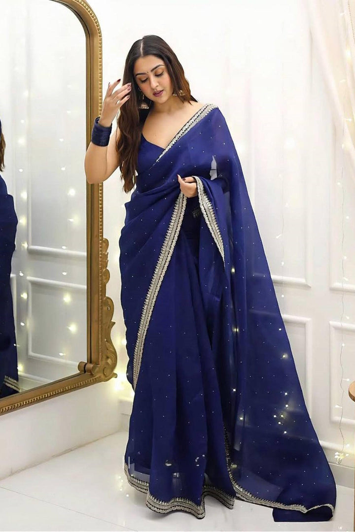 Woman wearing a blue saree with a white background