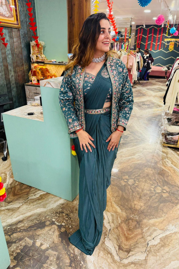 Woman in a teal outfit standing in a store with colorful decorations.