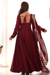 Burgundy evening gown with intricate detailing on a white background
