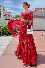 Woman in a pink floral dress standing on a rooftop with buildings in the background
