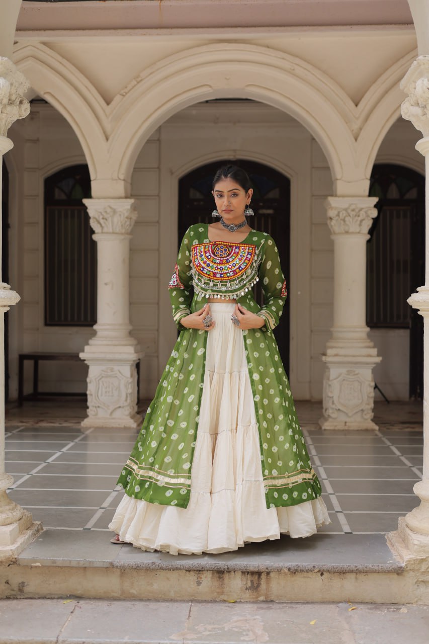 Woman in a green and white traditional outfit standing in front of an archway.
