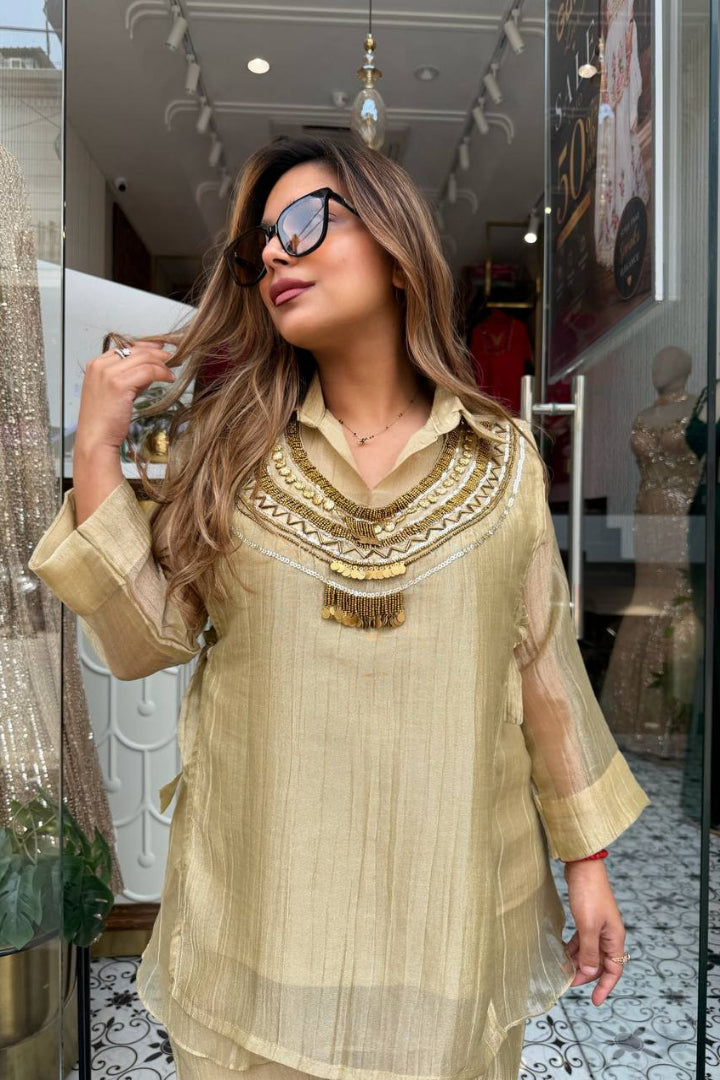 Woman wearing a beige embroidered dress in a store setting