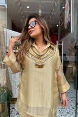 Woman wearing a beige embroidered dress in a store setting