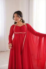 Woman wearing a red dress with a gold belt in a bright room.