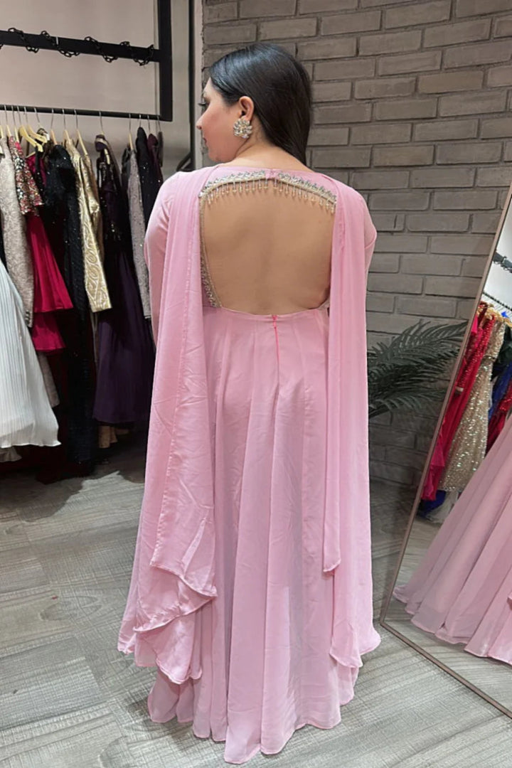 Woman wearing a pink saree with a backless blouse in a store setting.