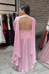 Woman wearing a pink saree with a backless blouse in a store setting.