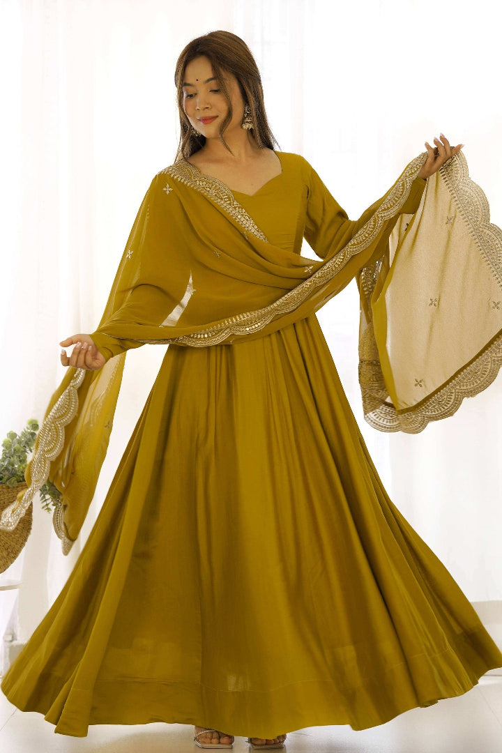 Woman wearing a mustard yellow traditional outfit with a beige dupatta against a white background