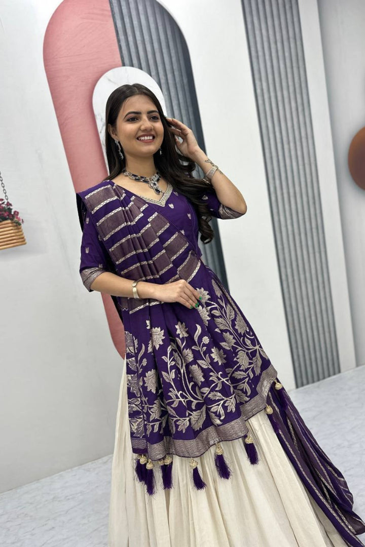Woman wearing a purple and white traditional outfit with floral patterns.