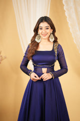 Woman wearing a traditional purple outfit with gold accents against a beige background