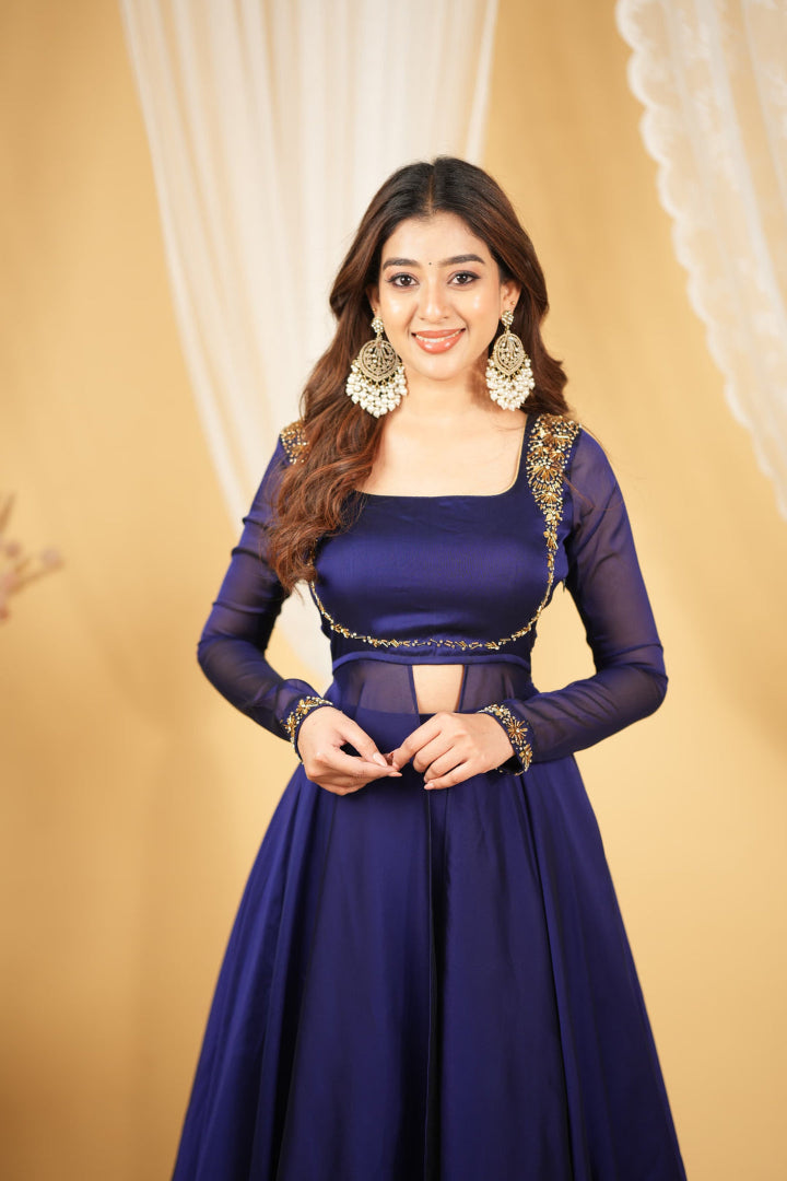 Woman wearing a traditional purple outfit with gold accents against a beige background