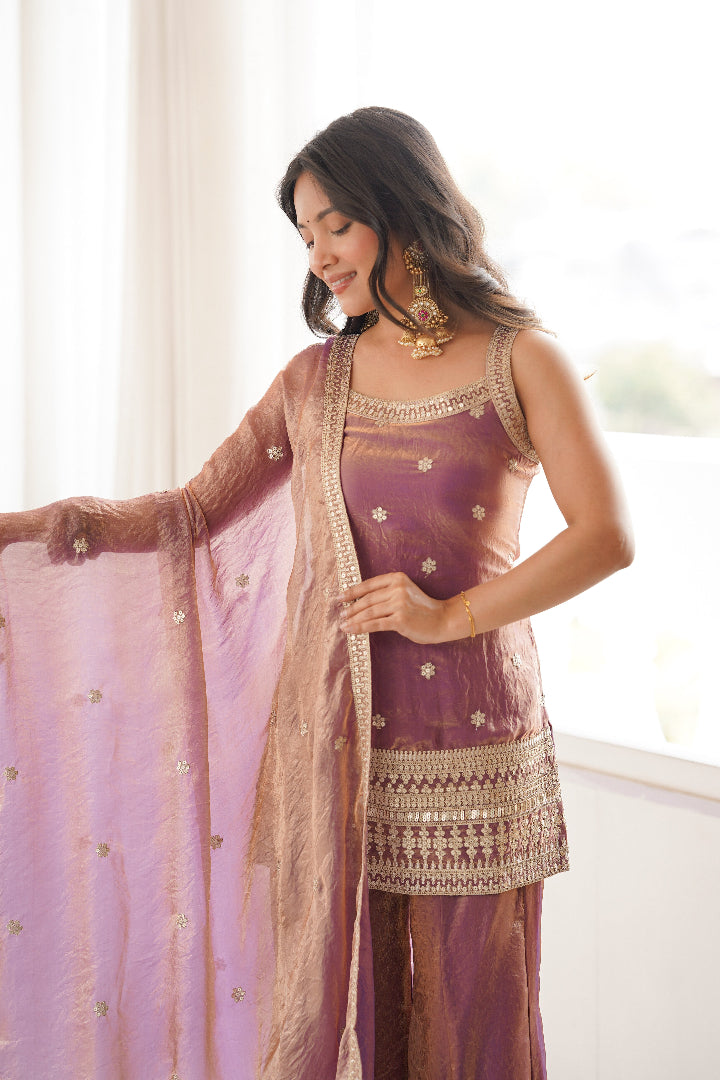 Woman in traditional outfit with a sheer dupatta indoors
