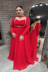 Woman in a red evening gown standing in front of a mirror.