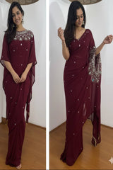 Woman wearing a maroon saree with silver embellishments against a white background