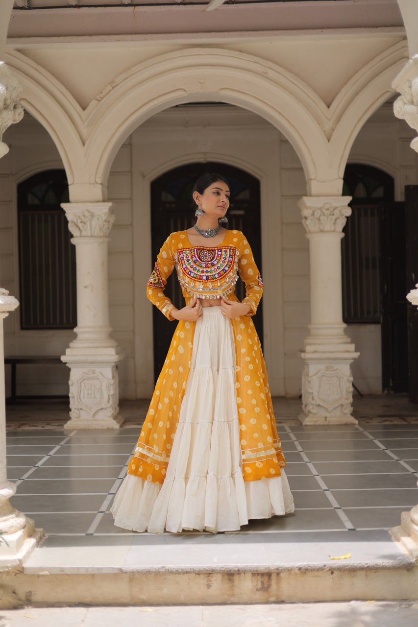 Woman in a traditional yellow and white outfit standing in an architectural setting.
