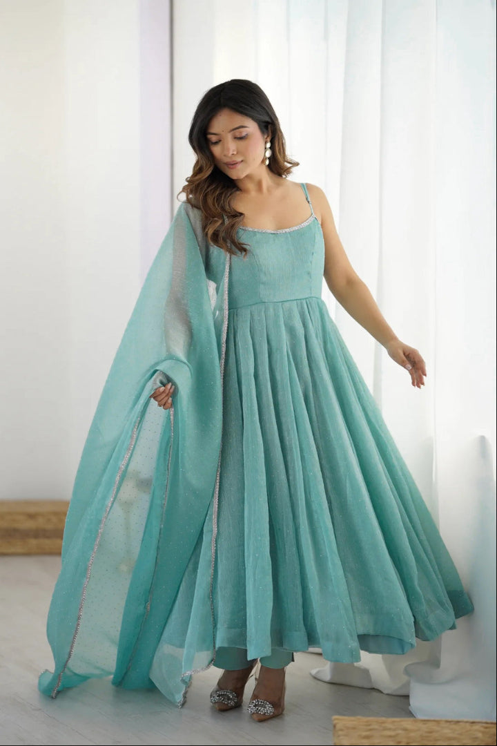 Woman wearing a light blue dress with a matching dupatta in a minimalistic setting