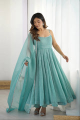 Woman wearing a light blue dress with a matching dupatta in a minimalistic setting