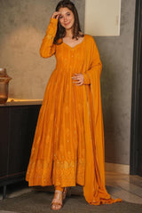 Woman wearing a mustard yellow dress with a matching dupatta indoors.