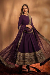 Woman wearing a purple traditional outfit with gold details on a brown background