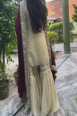 Person wearing a cream traditional outfit with maroon dupatta in an outdoor setting