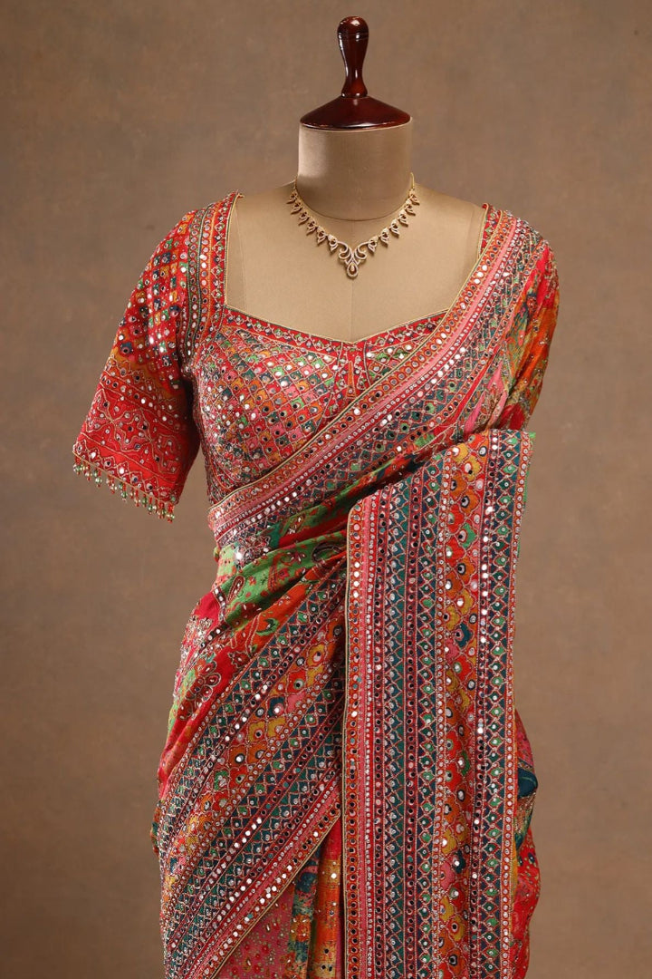 Colorful saree with intricate patterns on a mannequin against a brown background