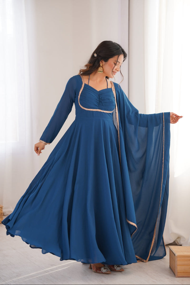 Woman wearing a blue dress with a flowing train in a bright room.